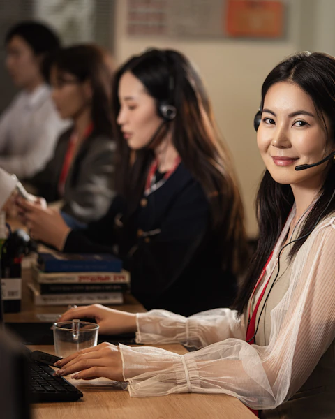 A service desk coordinator on a headset at her computer